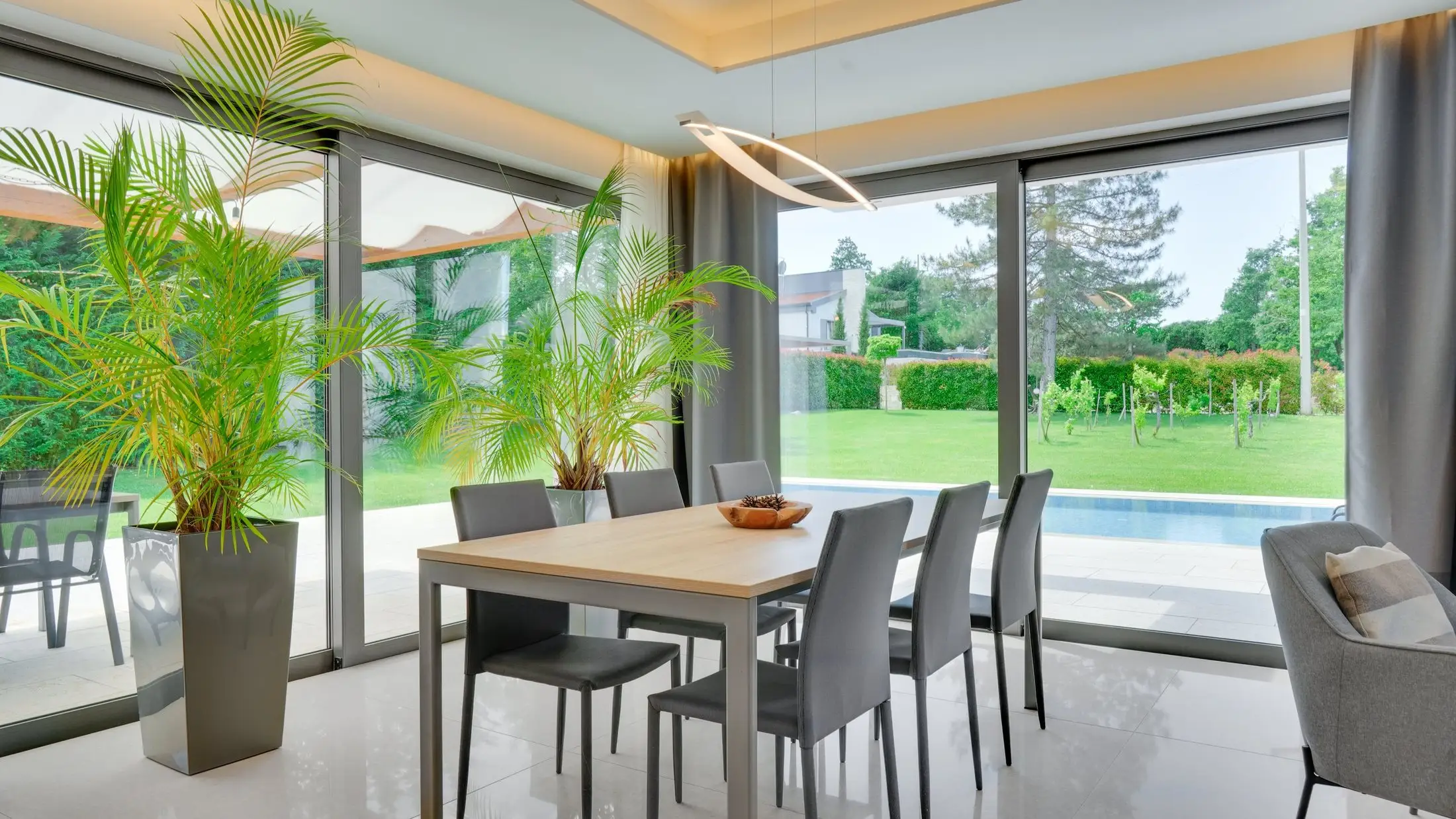 Esszimmer mit großer Fensterfront und Blick in den Garten