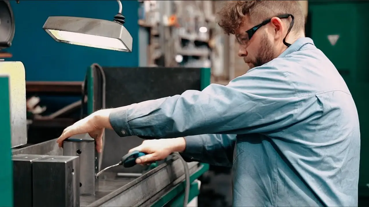 Szene aus dem Langfritz-Recruitingfilm: Mitarbeiter bei der Metallbearbeitung in der Werkstatt