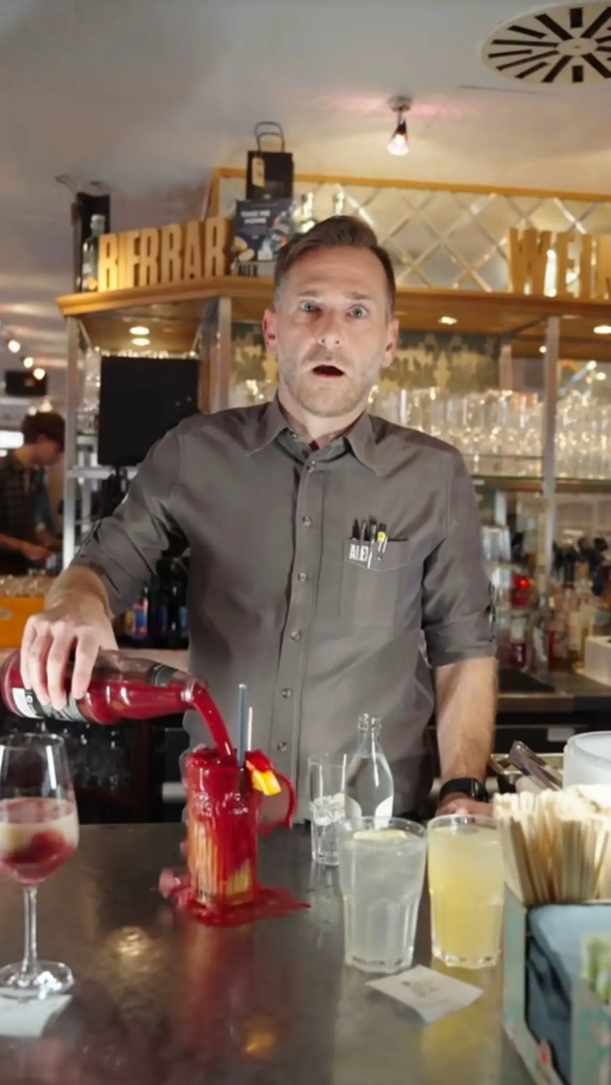 Barkeeper mixt einen Cocktail hinter der Theke, warmes Licht
